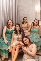 un grupo de asiático mujer en lujoso vestidos son esperando para cena en un hotel salón de baile foto
