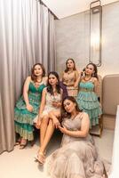 a group of Asian women in luxurious dresses are waiting for dinner in a hotel ballroom photo