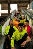 a group of Asian men are relaxing on the stairs with their friends at a university photo