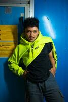 an Asian man with black curly hair posing in a green hoodie photo