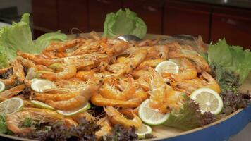 A large dish full of cooked shrimps with lemon and lettuce leaves video