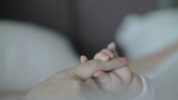 Baby daughter holding mum finger video