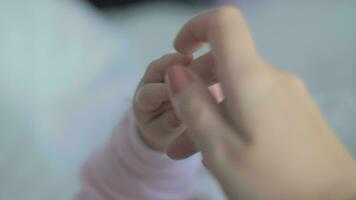 Baby's tiny fingers holding mother's hand video