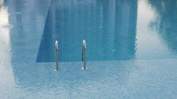 A shaky surface of an open swimming pool with a shiny railing video