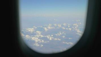 View to the clouds and land from flying airplane video