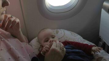 Mother playing with baby daughter in plane video