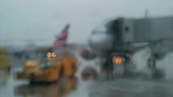 rebocar trator e aeronaves, Visão em chuvoso dia através a terminal janela video