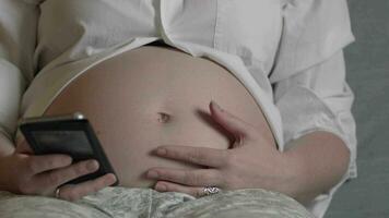 zwanger vrouw chillen met een smartphone video