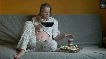 embarazada mujer Relajado en un sofá video
