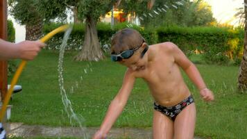 Mum and son having fun with pouring over from hose video