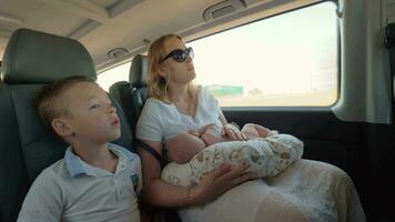 Mother with elder son and baby daughter traveling by car video