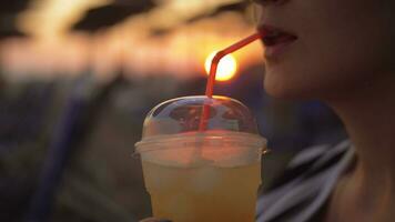 vrouw hebben bevroren drinken Aan de strand Bij zonsondergang video