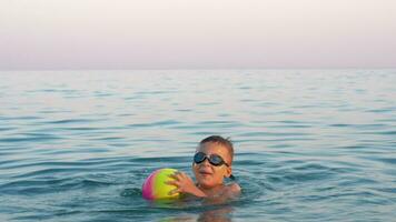 content enfant baignade dans le mer avec Balle video