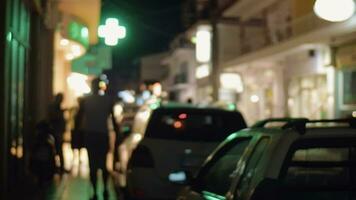 noche pueblo calle con estacionado carros y iluminado pancartas video