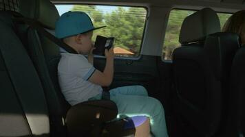chico tomando imágenes con célula cuando de viaje por coche video