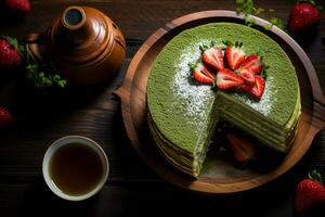 Top down view of a sliced matcha cake with layers of cream, strawberries, and green tea powder, next to a wooden matcha whisk and black lacquered bowl, indirect natural light. AI Generated. photo