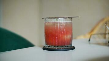 A glass of grape juice with lychee inside on white table on blurred cafe background. photo