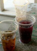 Soft drink and ice in the disposable plastic glasses photo