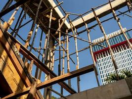 Temporary wooden pole for supports the concrete structure a building under construction photo