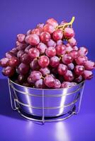 A stainless steel basket filled with sorted grapes isolated on a gradient background photo