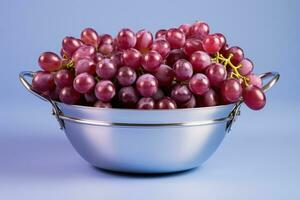 A stainless steel basket filled with sorted grapes isolated on a gradient background photo