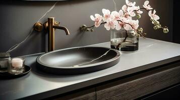 Close up chic bathroom with oval sink, empty countertop, wooden vanity, black framed mirror, flower and grey wall. Generative AI photo