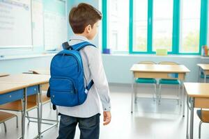 Back view of a schoolboy with a backpack standing in the classroom. Pro Photo