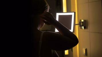 kvinna ser i badrum spegel efter applicering ansiktsbehandling grädde video
