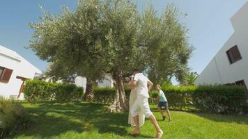 contento genitori e bambini nel verde giardino con grande oliva albero video