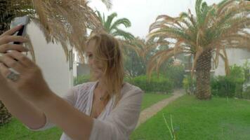 alegre mulher fazer verão selfie em chuvoso dia video