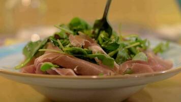 Green salad with prosciutto as appetizer at the restaurant video
