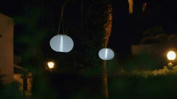 Garden with white Chinese lanterns at night video