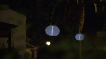 House garden with white paper lanterns at night video