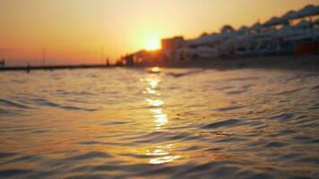 zomer tafereel van zee en toevlucht Bij gouden zonsondergang video