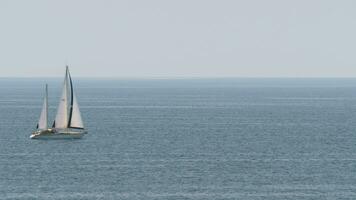 Yacht with sails in quiet blue sea video