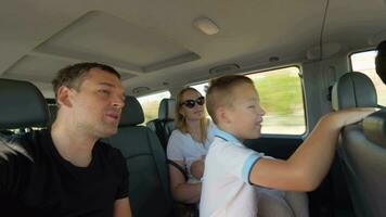 Parents with two kids having car journey video