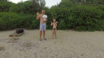 gelukkig vader en zoon golvend handen naar Copter camera video