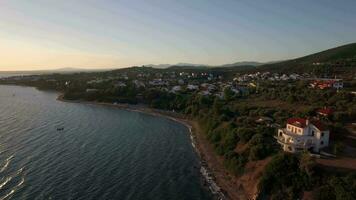 Aerial view of sea and shore with resort town at sunset, Greece video