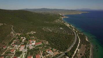 Seashore with cottages and green hills Aerial view of Trikorfo Beach, Greece video