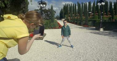 mamá haciendo foto de un niño en bahai jardín acre, Israel video