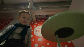 Kid playing with spinning disc at the exhibition of Yayoi Kusama video