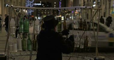 Man playing on glass bottles to earn money video