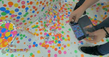 Woman taking photo in Obliteration Room by Yayoi Kusama video