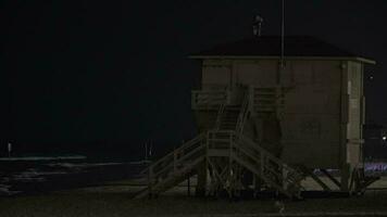 Lifeguard tower with blinking light on the beach at night video