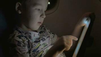 Boy traveling by plane and playing game on tablet PC video