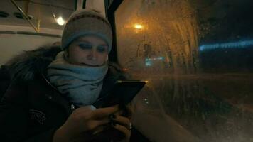 donna utilizzando cellula mentre in viaggio di autobus nel notte città video