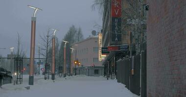 besneeuwd straat met auto's Aan de weg in rovaniemi, Finland video