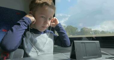 Child in train talking on mobile using hands free set video