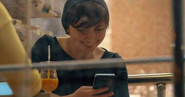 mujer atraído a móvil Los telefonos durante reunión en café video