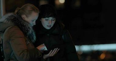 Dames met digitaal tablet in avond straat video